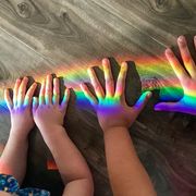 children’s hands playing with a rainbow