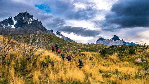 https://www.nationalgeographic.com/content/dam/adventure/photos/2017/stories/chilean-adventure-gallery/chilean-adventures-back-packers-torres-del-paine.jpg Een groep wandelaars trekt over de grasvlakten van het Parque Nacional Torres del Paine Omdat het weer hier snel kan omslaan moeten bezoekers zich goed voorbereiden met zonnebrandcrme en een warm en waterdicht jack