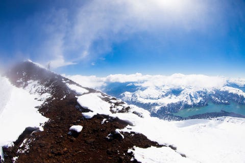 https://www.nationalgeographic.com/content/dam/adventure/photos/2017/stories/chilean-adventure-gallery/chilean-adventures-lake-district-chile-hike.jpg Wolken glijden over een smalle piek in het Merengebied van Chili een regio met besneeuwde vulkanen glinsterende meren en oeroude wouden De meeste bezoekers beginnen hun reis in dit gebied door naar de stad Puerto Montt te vliegen en vandaaruit de omringende natuur te verkennen