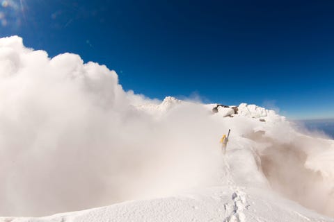 https://www.nationalgeographic.com/content/dam/adventure/photos/2017/stories/chilean-adventure-gallery/chilean-adventures-lake-district-chile.jpg Op de top van een berg in het Merengebied van Chili loopt een skir met zijn uitrusting door een wolk In deze regio in het zuiden van Chili liggen talloze skioorden vanwaaruit wintersportliefhebbers routes kunnen verkennen die bij vulkaanuitbarstingen zijn gevormd