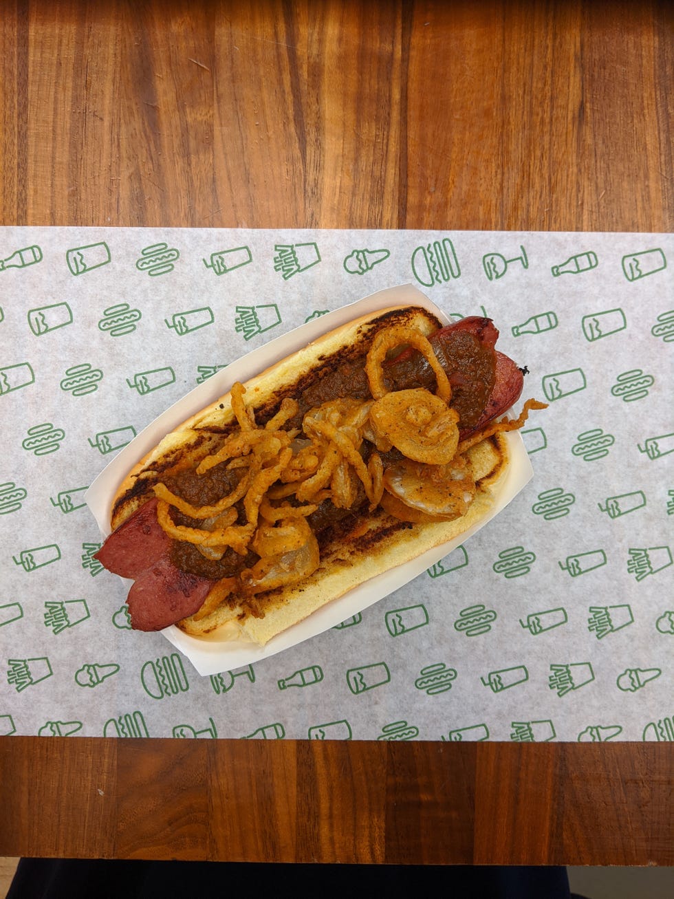 hot dog topped with a no bean chili and crispy friend onions