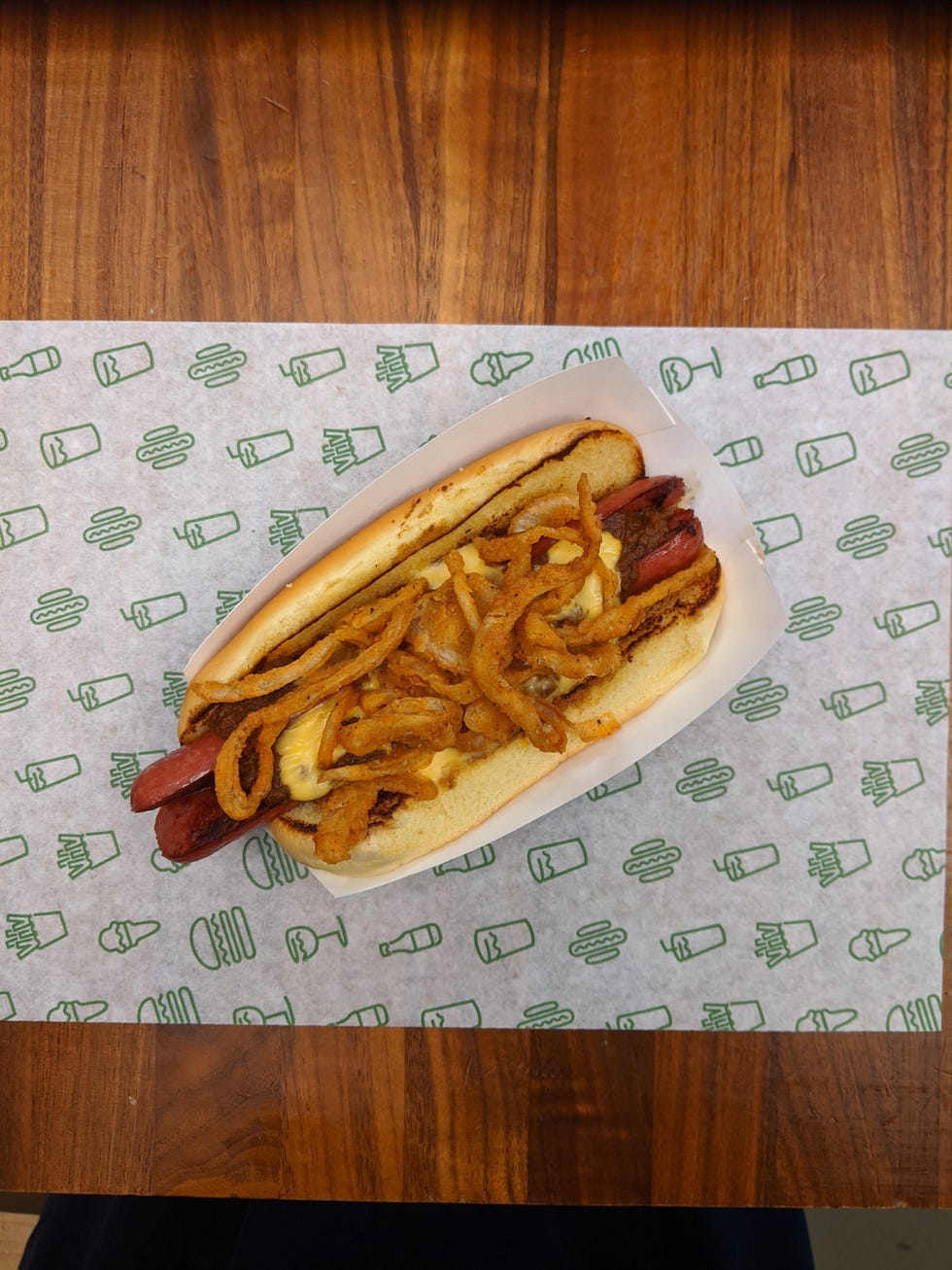 hot dog topped with no bean chili, melted cheddar and american cheese and crispy fried onions