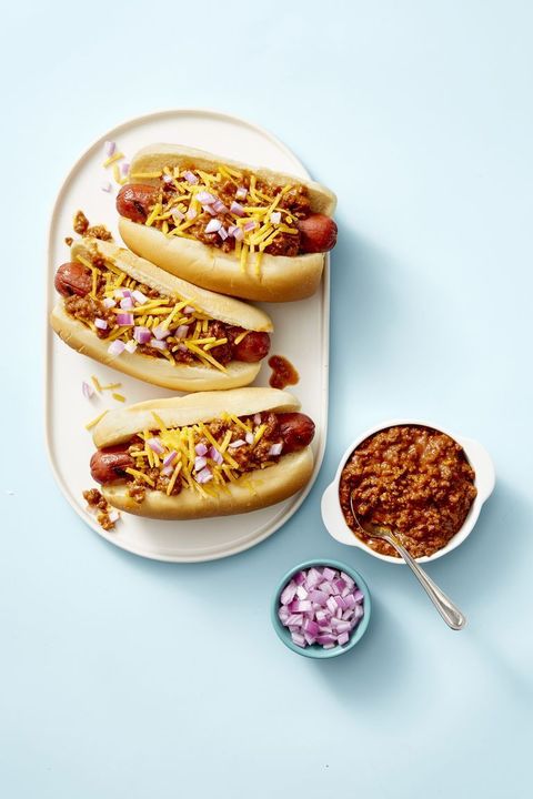 chili dogs with cheese and red onion on top