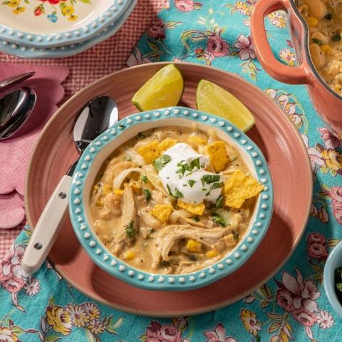 white chicken chili with chips and lime wedges