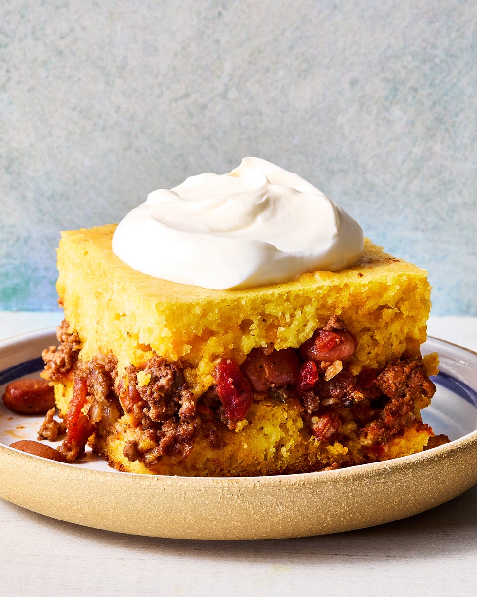cornbread in a casserole dish with a layer of chili in the middle