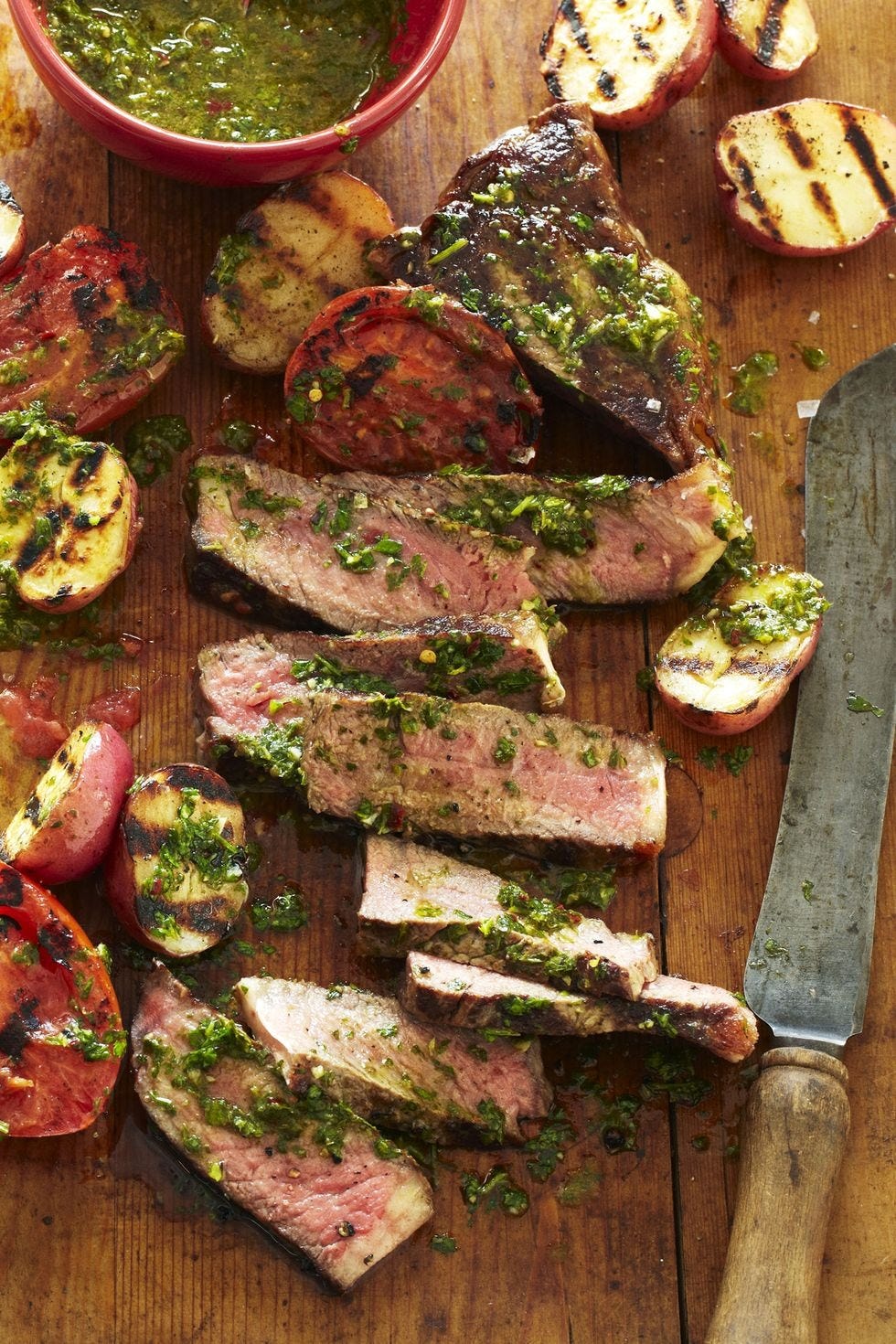 chimichurri strip steak on a wooden board