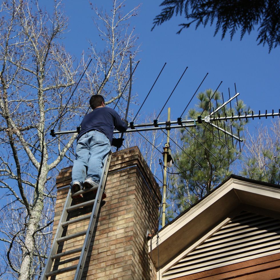 chimney sweep working on a ladder
