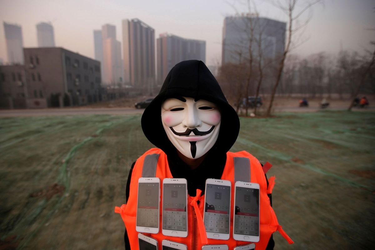 Kunstenaar Liu Bolin draagt een masker en een vest met daarop 24 mobiele telefoons terwijl hij de vieze lucht van Beijing live op internet streamt Deze foto werd genomen op 19 december 2016  de vierde achtereenvolgende dag waarop code rood voor een gevaarlijk niveau van luchtvervuiling werd afgekondigd