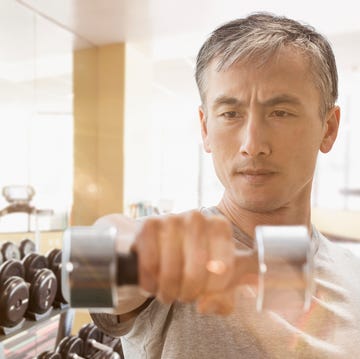 chinese man lifting weights in gym