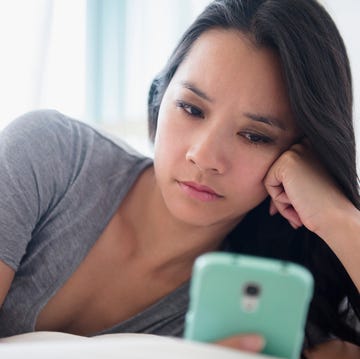 Woman staring at phone on bed- slow fade Woman staring at phone on bed- slow fade