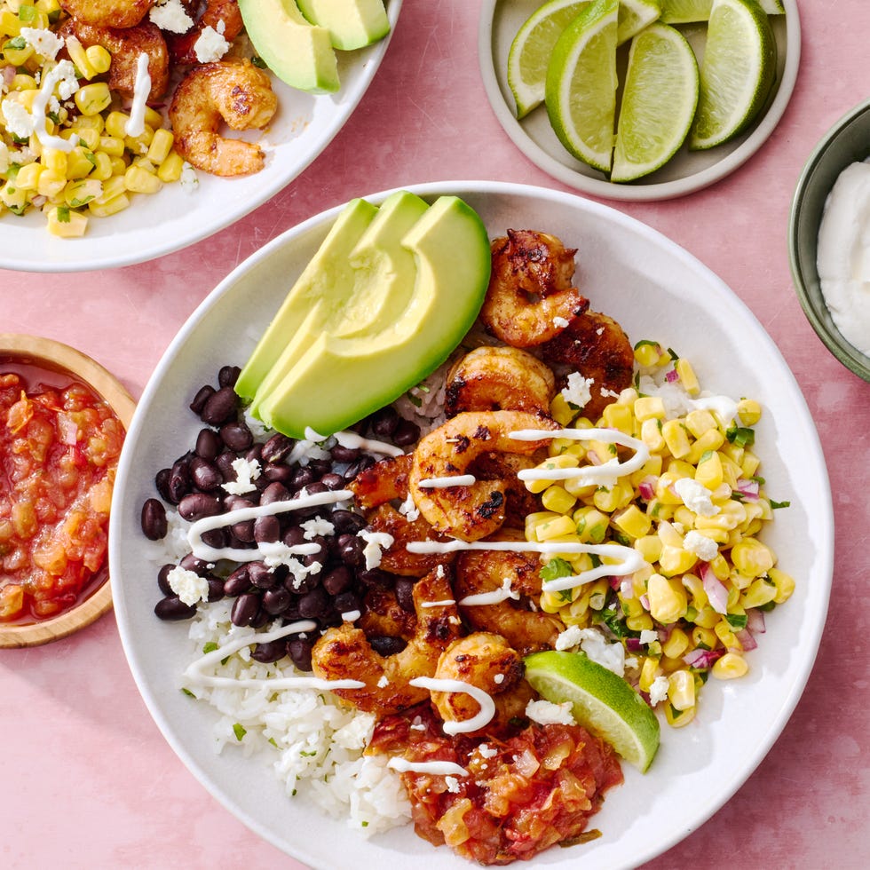 chipotle shrimp with black beans, corn salsa, salsa, and avocado in a rice bowl