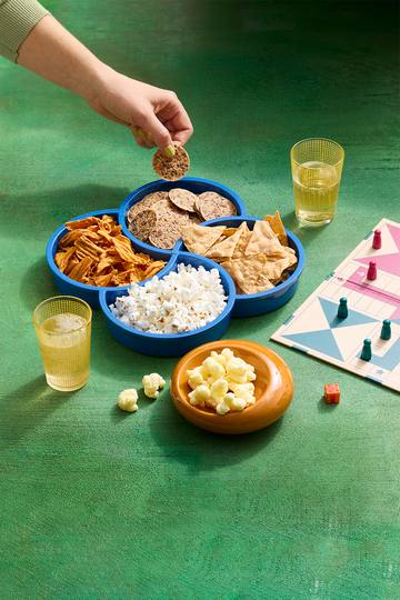 assorted crackers, chips and puffs alongside a board game