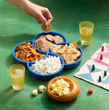Assorted crackers, chips and puffs alongside a board game assorted crackers, chips and puffs alongside a board game