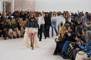 Fashion show runway featuring models in various outfits and an audience