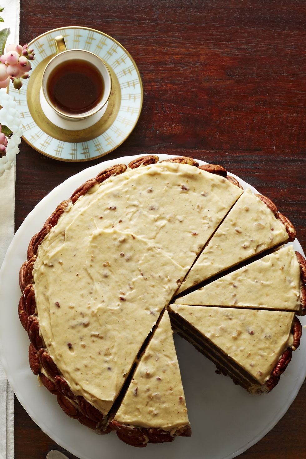 a round cake with spiced pumpkin frosting on top and pecans on the side