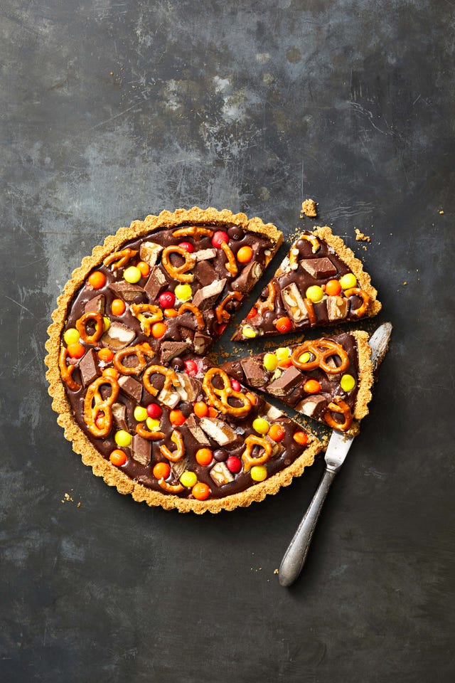 chocolate candy pretzel tart sliced into wedges with a knife