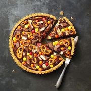 chocolate candy pretzel tart sliced into wedges with a knife