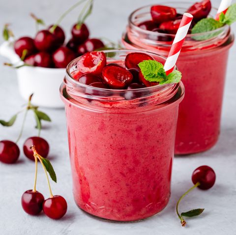 cherry smoothie in glass jars with mint leaves and fresh berries