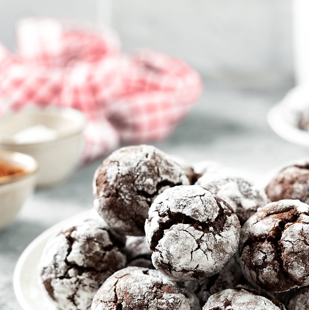homemade chocolate and coffee crinkle cookies in a white plate on the kitchen table traditional american cookies for christmas with cracks and powdered sugar on a culinary background shutterstock id 2141499079 purchaseorder woman's day job december 2022 client wdy120122sunday other roni martin chance2141499079