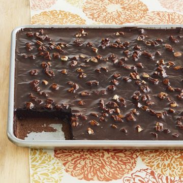 chocolate sheet cake in sheet pan with nuts on top