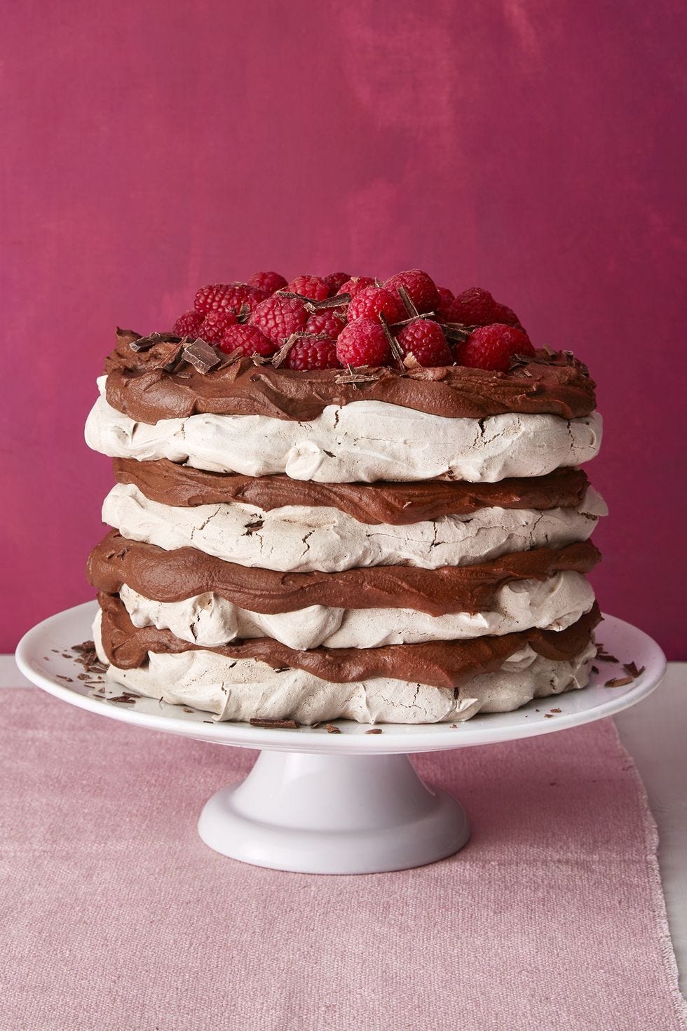 chocolate meringue layer cake on a white cake stand