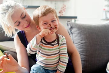 niño comiendo chocolate encima de su madre