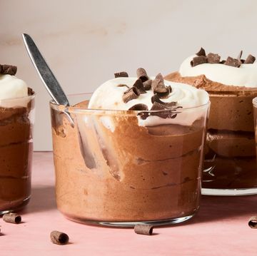 chocolate mousse in containers topped with whipped cream and chocolate shavings