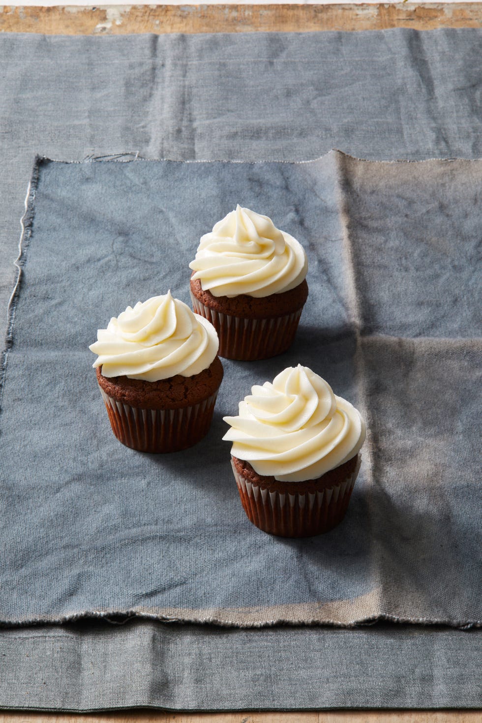 chocolate pecan cupcakes with white frosting on top