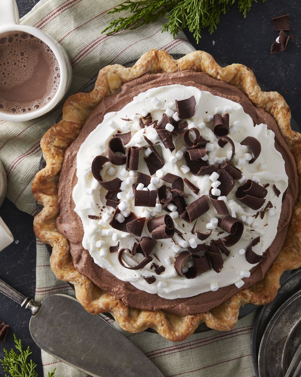 hot chocolate ice box pie in a pie tin with two mugs of hot cocoa next to it