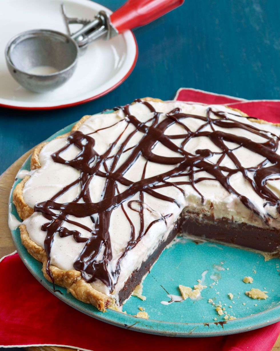 mississippi mud pie in a teal pie plate with chocolate drizzled on top