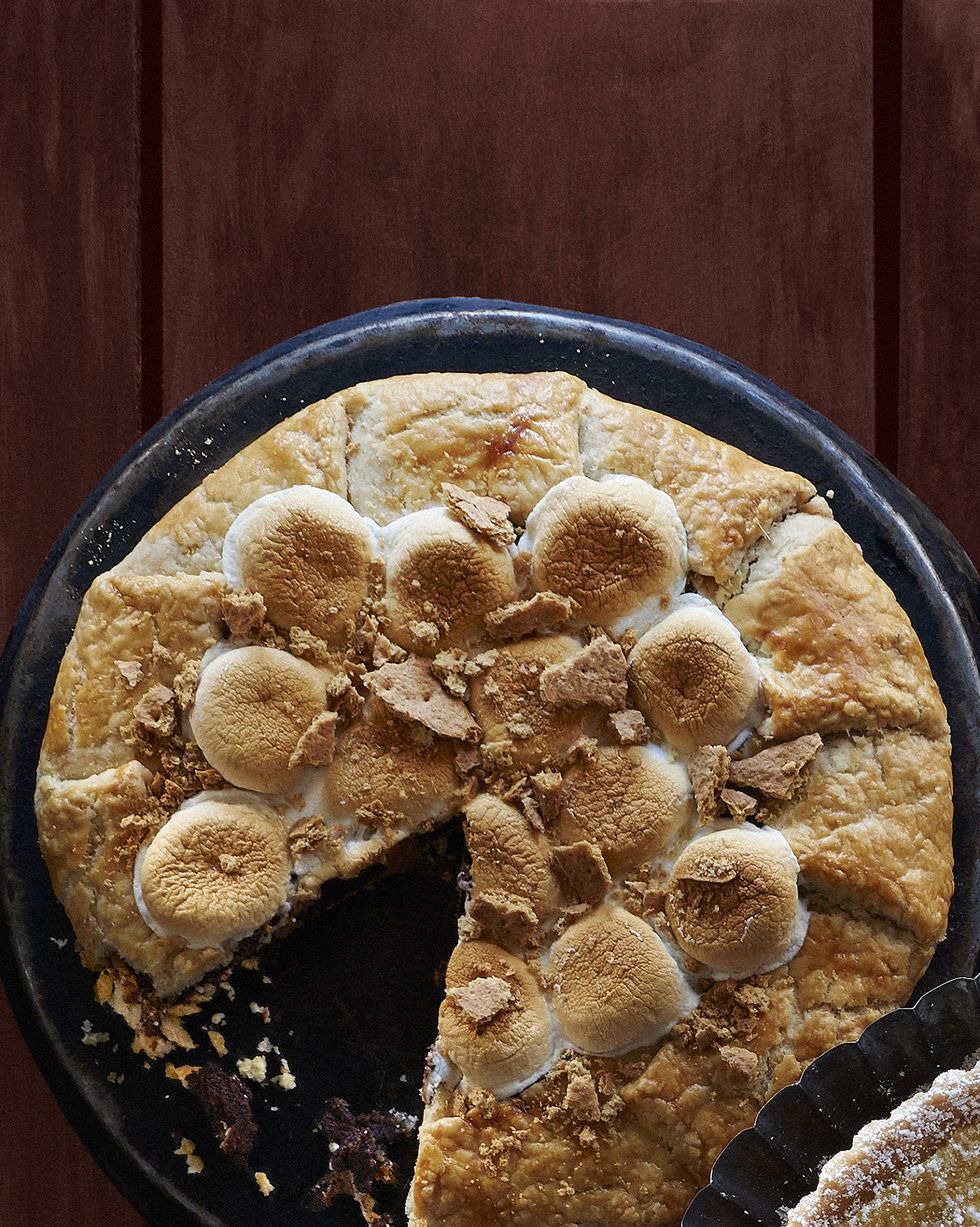 smores galette on a metal plate with toasted marshmallows on top and a slice removed