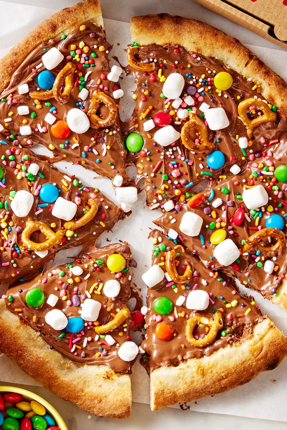 chocolate covered pizza dough topped with marshmallows, pretzels, and candy