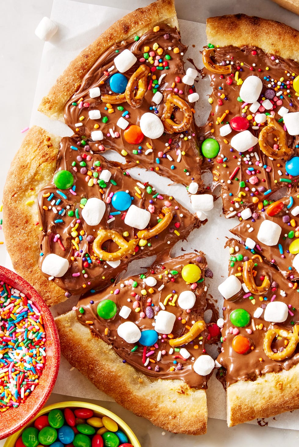 chocolate covered pizza dough topped with marshmallows, pretzels, and candy