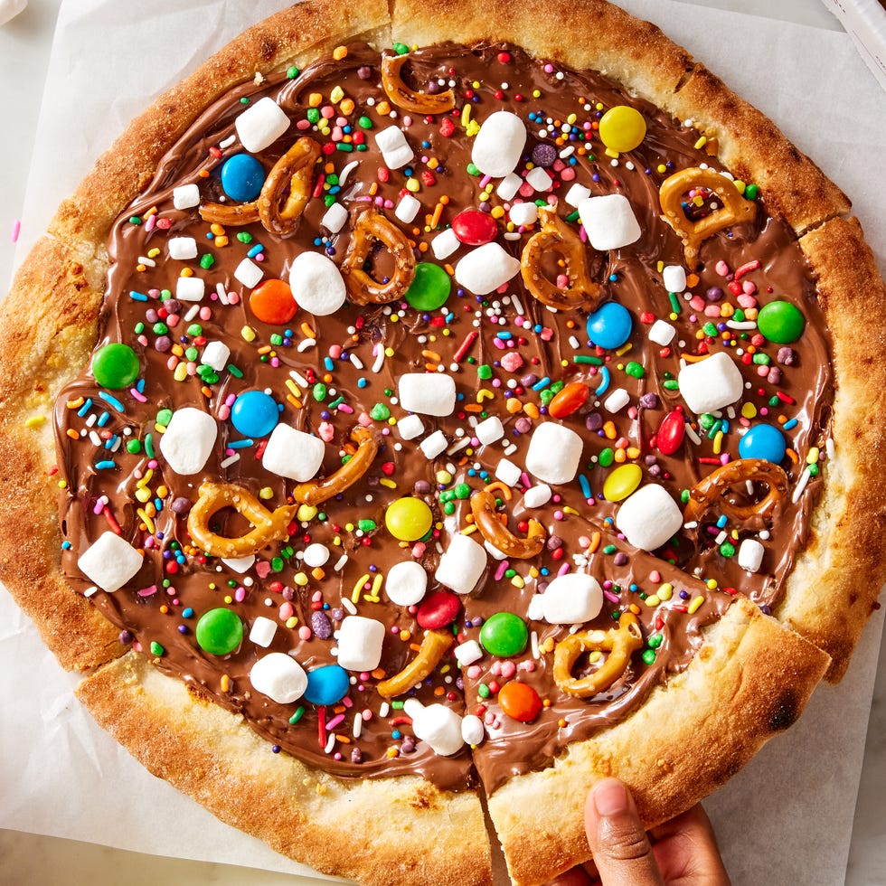 chocolate covered pizza dough topped with marshmallows, pretzels, and candy