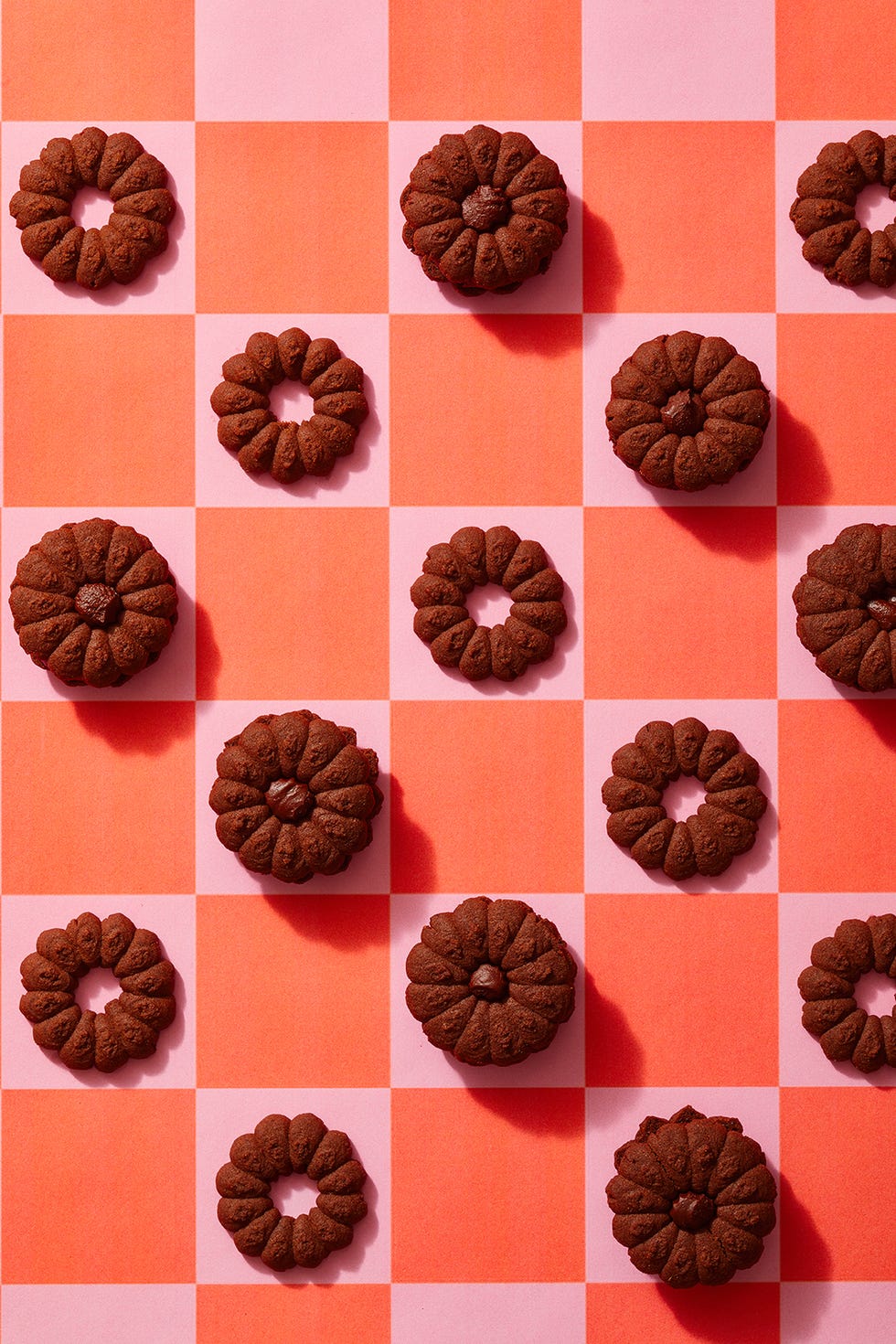 chocolate spritz cookies on a pink and red checkered background