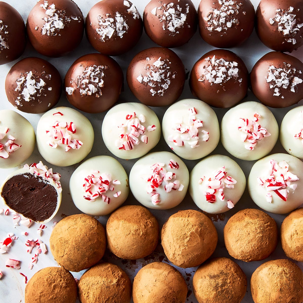 chocolate truffles topped with candy canes, sea salt, and cocoa powder
