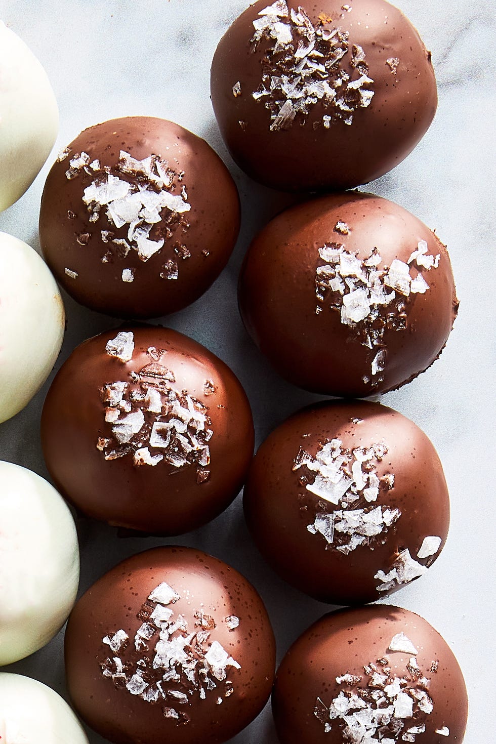 chocolate truffles topped with candy canes, sea salt, and cocoa powder