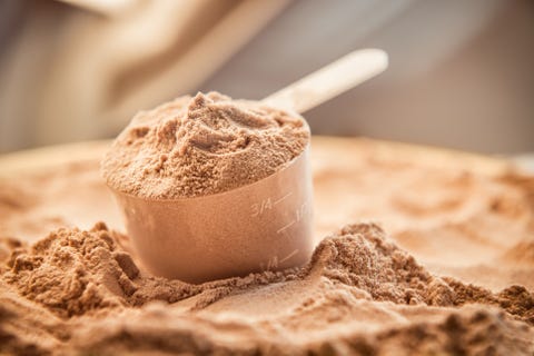 Chocolate whey protein powder with a filled scoop Chocolate whey protein powder with a filled scoop