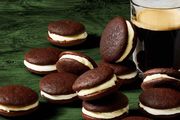 chocolate whoopie pies next to a glass of dark beer