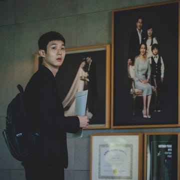 a person observing a collection of framed photographs and artworks on a wall a person observing a collection of framed photographs and artworks on a wall
