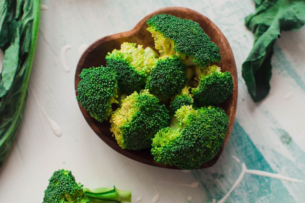 chopped broccoli on a wooden heart shaped bowl
