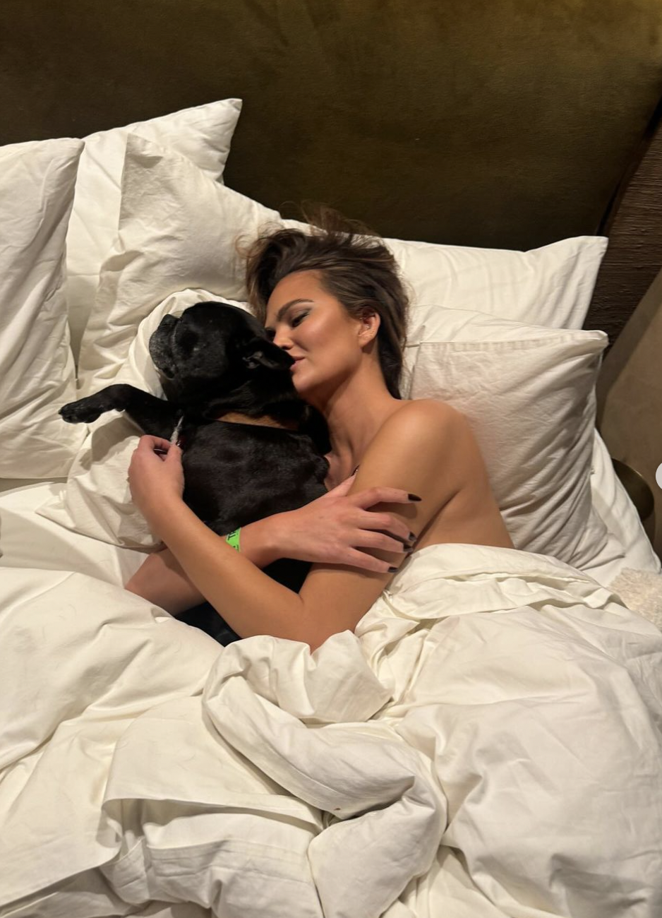 a person lying in bed with a dog