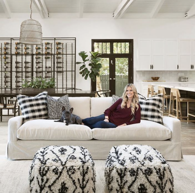 christina anstead sitting on a couch next to her dog