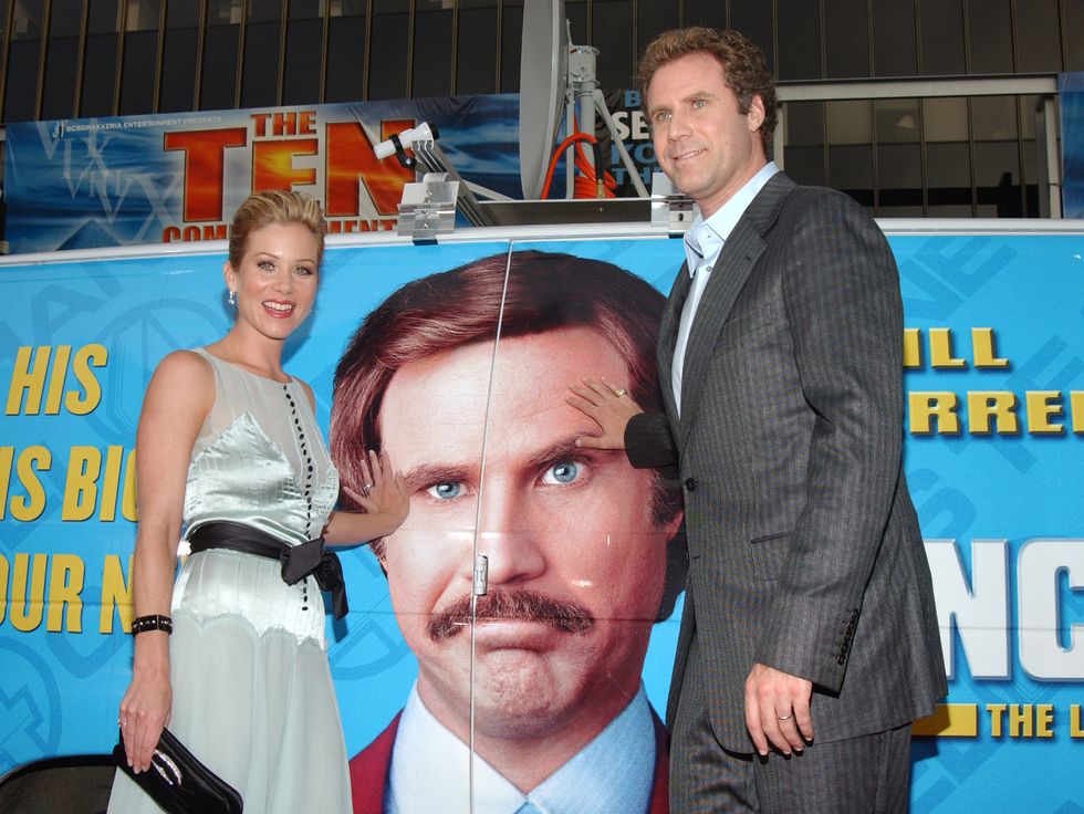 christina applegate and will ferrell standing in front of a poster for their film anchorman at a premiere event