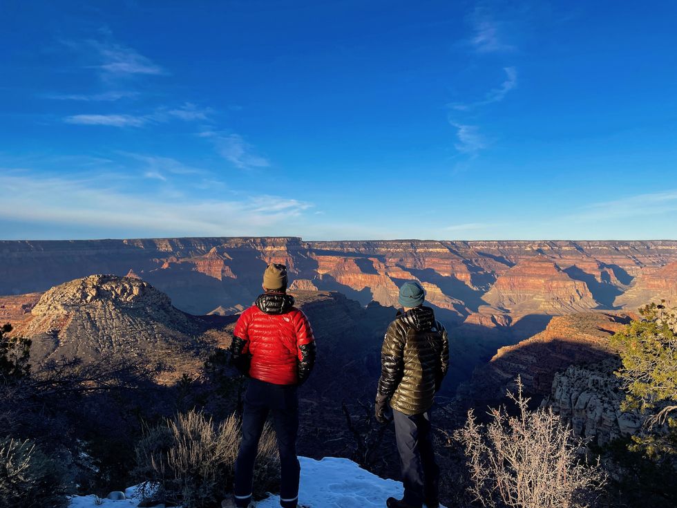 mike foote and rob krar look down into the grand canyon from atop the south rim