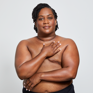 christina miner posing on a white background covering a partial area of their chest showing their scars from surgery