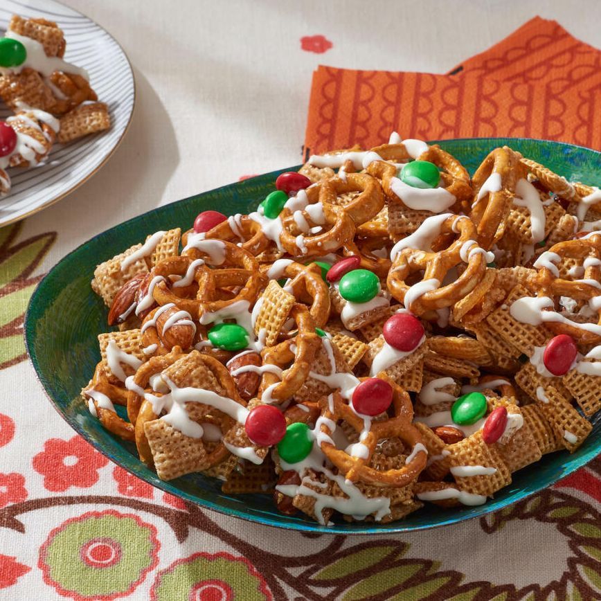 christmas chex mix in green bowl with orange napkins
