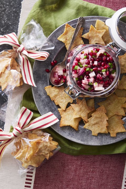 holiday salsa in a jar on a metal plate with homemade tortilla chips shaped like christmas trees and stars