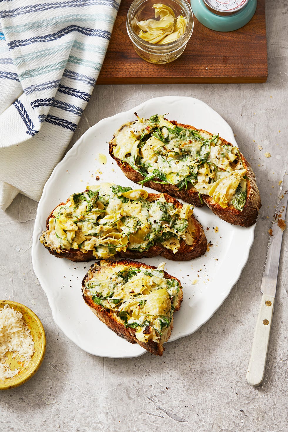 spinach artichoke tartines on a white plate