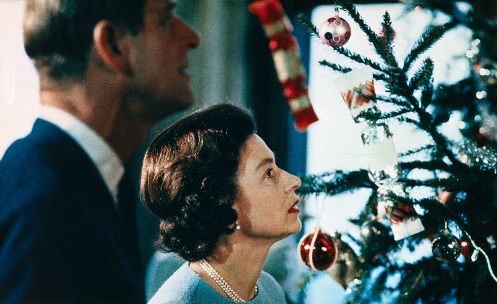 queen elizabeth and prince philip looking at christmas tree